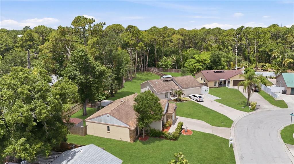 An aerial view shows two suburban houses with driveways surrounded by a dense forest — 2108 E 56TH AVENUE TERRACE, BRADENTON, FL