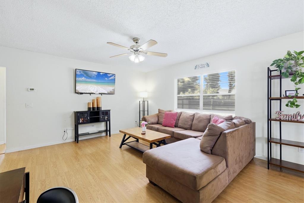 A living room features a brown sectional sofa, a wooden coffee table, and light flooring — 2108 E 56TH AVENUE TERRACE, BRADENTON, FL