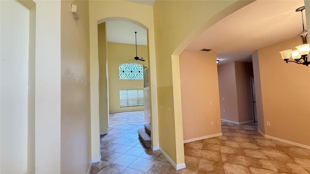 An interior view shows a tiled foyer leading to a living area with high ceilings — 3559 SUNSET ISLES BOULEVARD, KISSIMMEE, FL