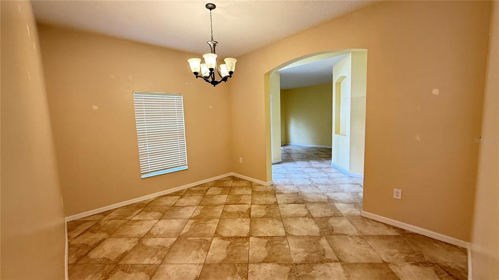 A dining room with tan walls, a chandelier, and diagonal tile flooring — 3559 SUNSET ISLES BOULEVARD, KISSIMMEE, FL