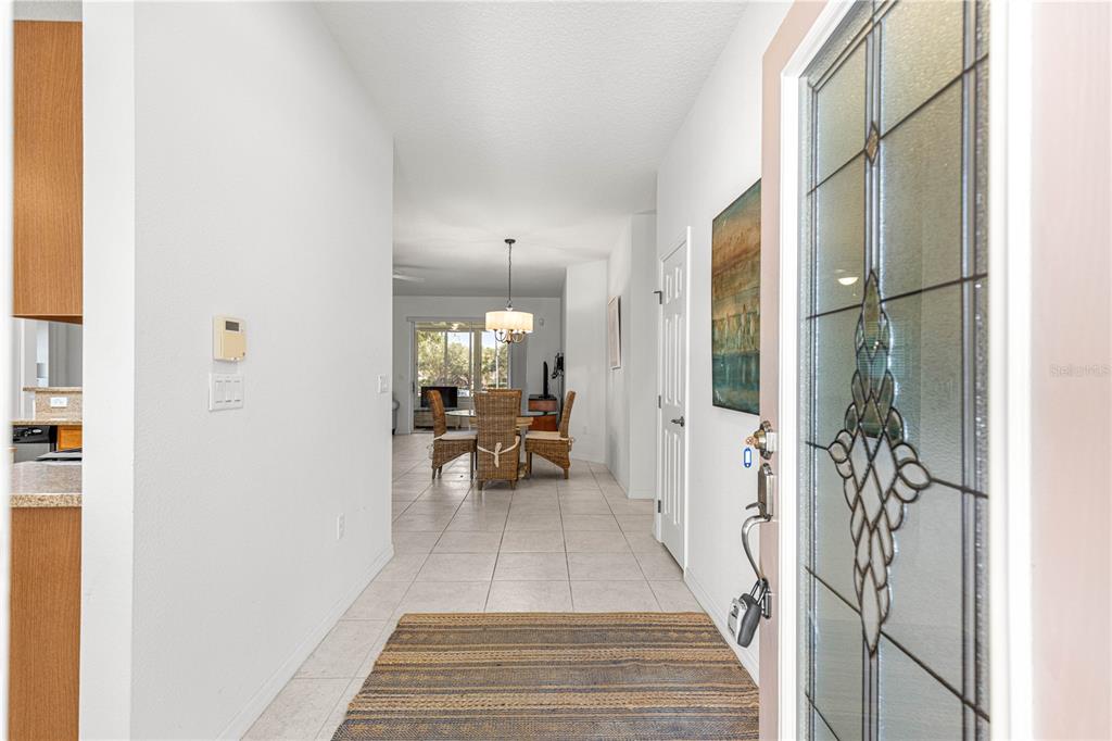 An entryway with tile flooring leads into a dining area with a wicker table set — 9317 SW 94TH LOOP, OCALA, FL