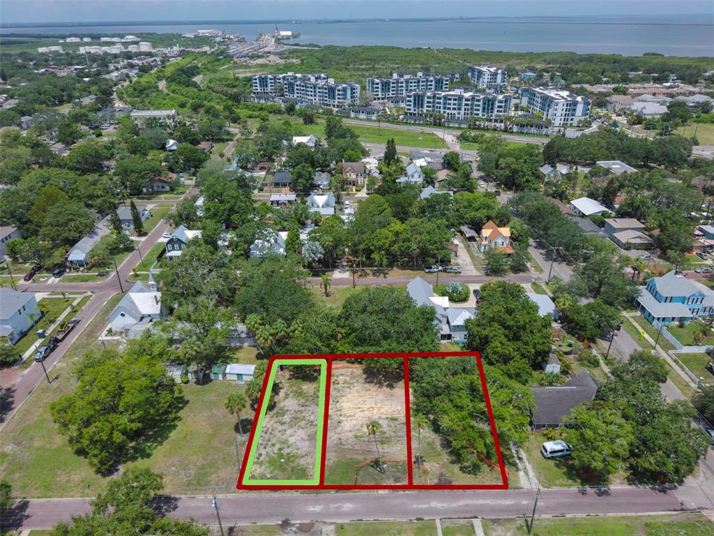 An aerial view shows three adjacent vacant lots in a residential neighborhood near the water — 6909 S SPARKMAN STREET, TAMPA, FL