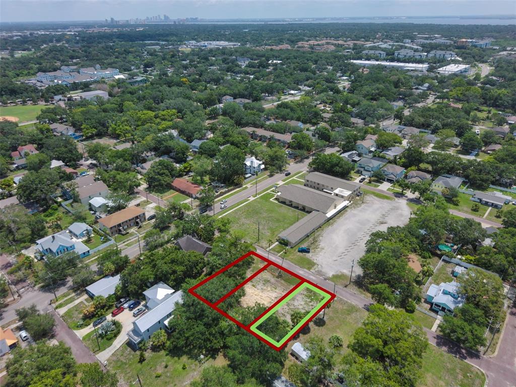 An aerial view shows a vacant lot outlined in red and green in a residential neighborhood — 6909 S SPARKMAN STREET, TAMPA, FL