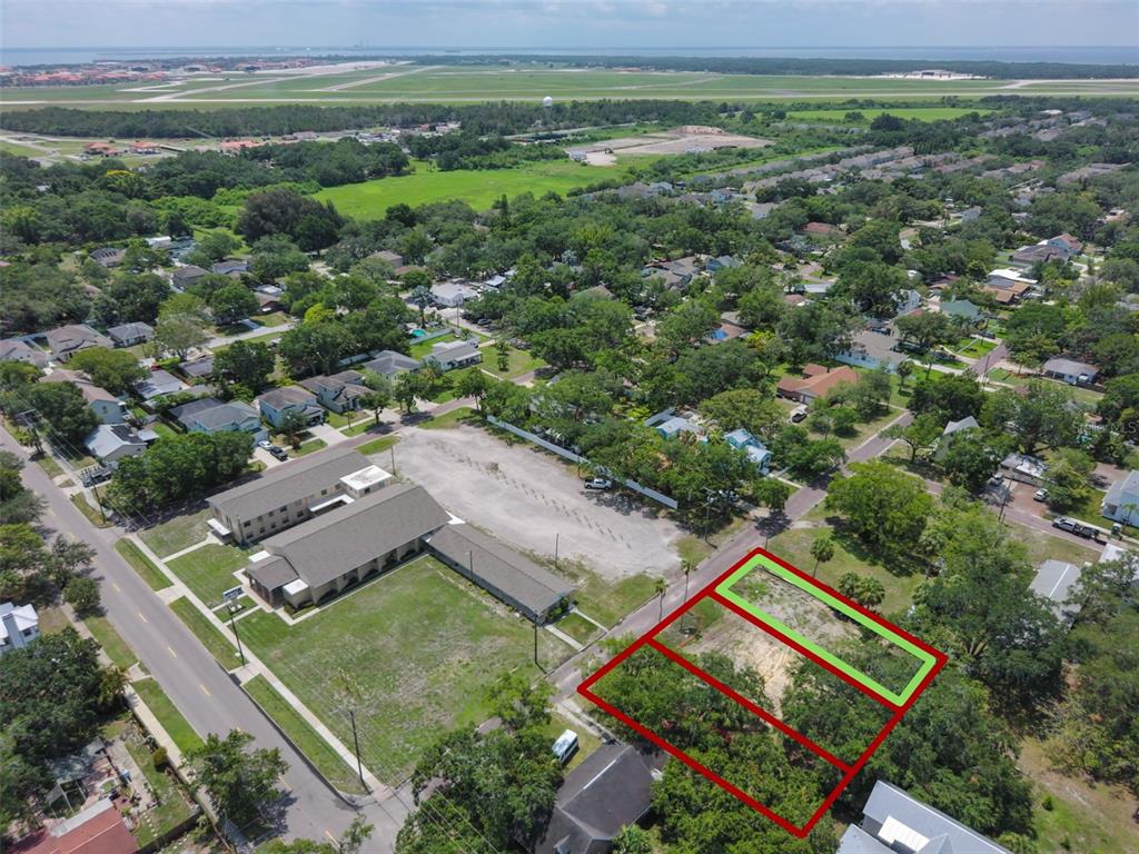 An aerial view shows three adjacent vacant lots outlined in red and green near buildings — 6909 S SPARKMAN STREET, TAMPA, FL