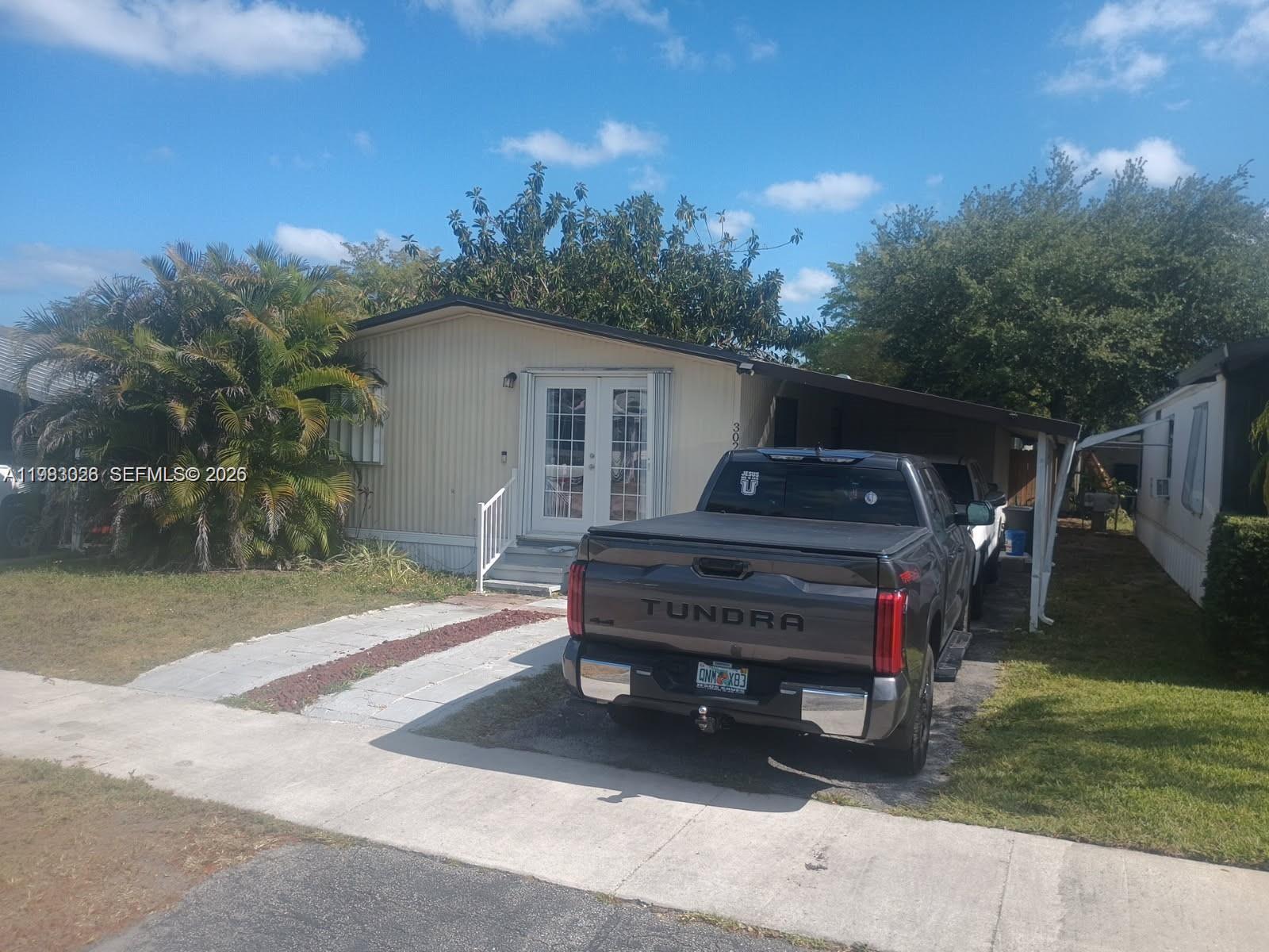 A single-story manufactured home with a carport and a pickup truck parked in front — 3024 SW 51st St, Dania Beach FL 33312, DANIA BEACH, FL