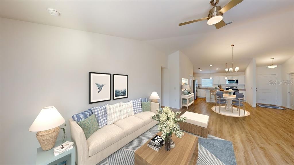 A living room with a beige sofa, wooden coffee table, and an open-concept kitchen — 1620 GERANIUM AVENUE, NORTH PORT, FL
