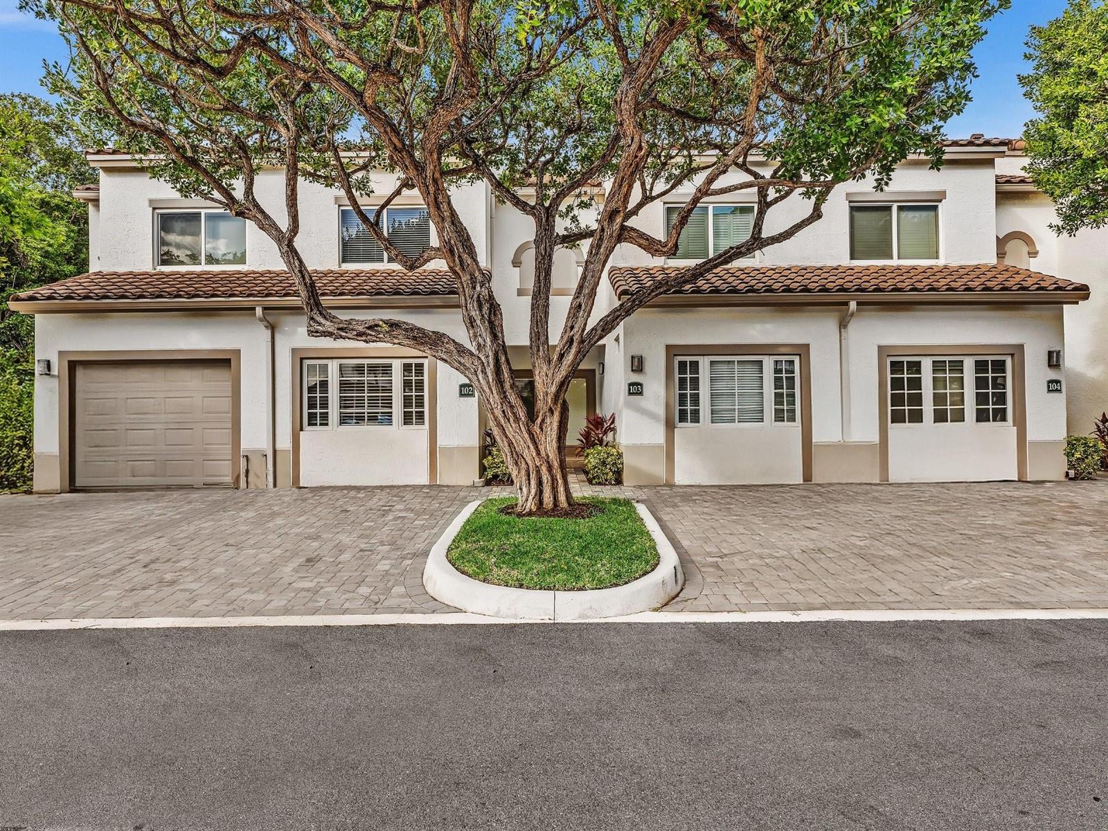 A two-story townhouse exterior with a large tree in front of the entrance — 3602 S Ocean Boulevard # 102, Highland Beach FL 33487, HIGHLAND BEACH, FL