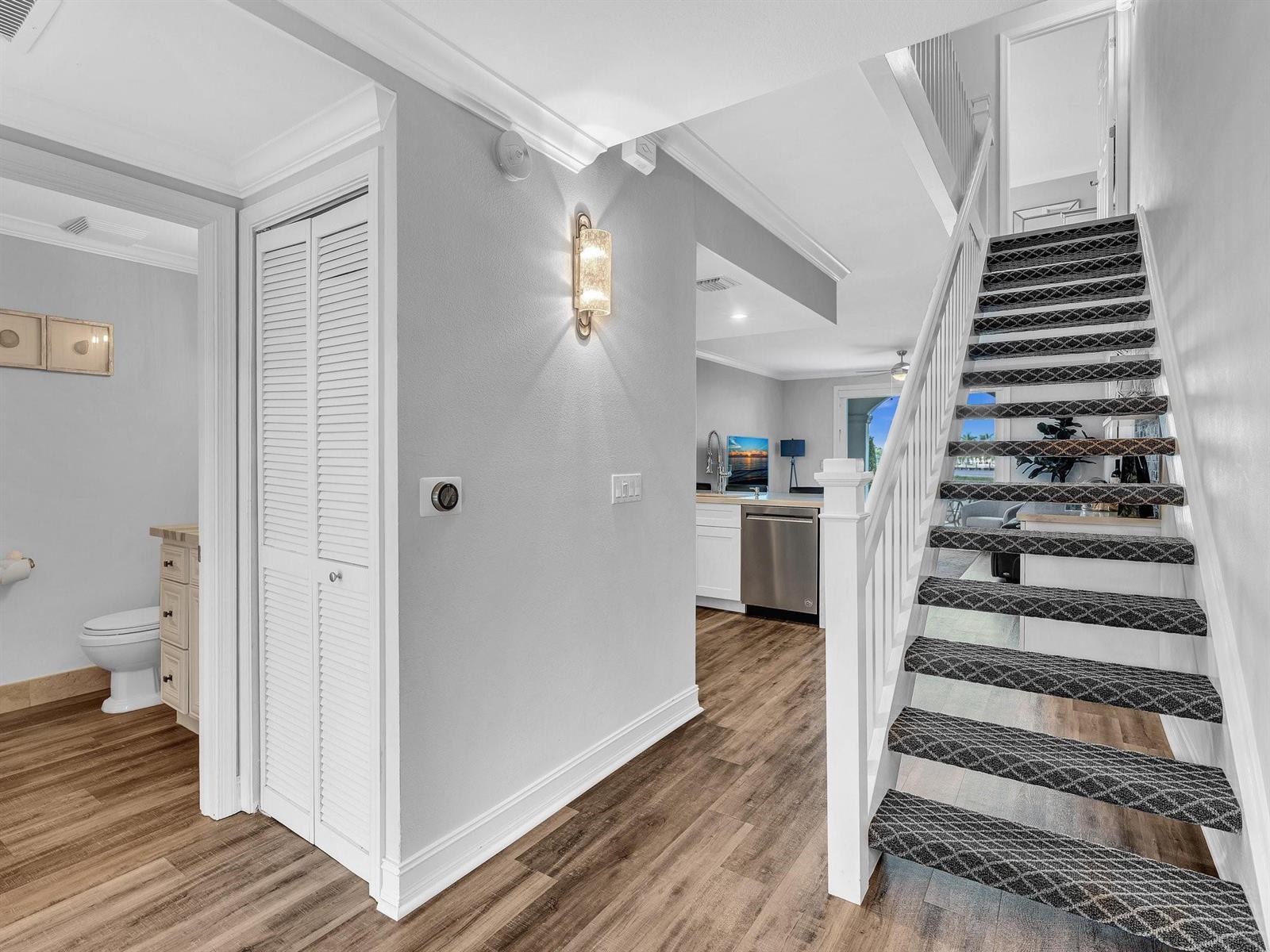 An interior view shows a staircase with patterned carpet, wood flooring, and a nearby bathroom — 3602 S Ocean Boulevard # 102, Highland Beach FL 33487, HIGHLAND BEACH, FL