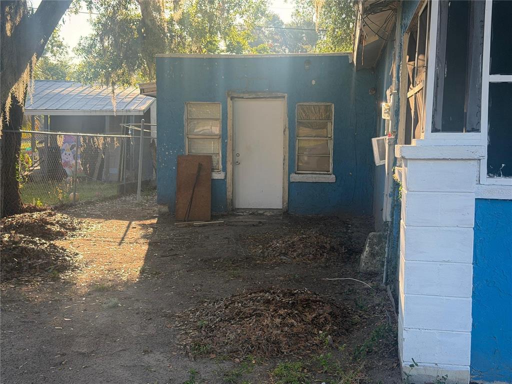 A blue exterior wall features a central white door flanked by two windows — 470 S EAST AVENUE, BARTOW, FL