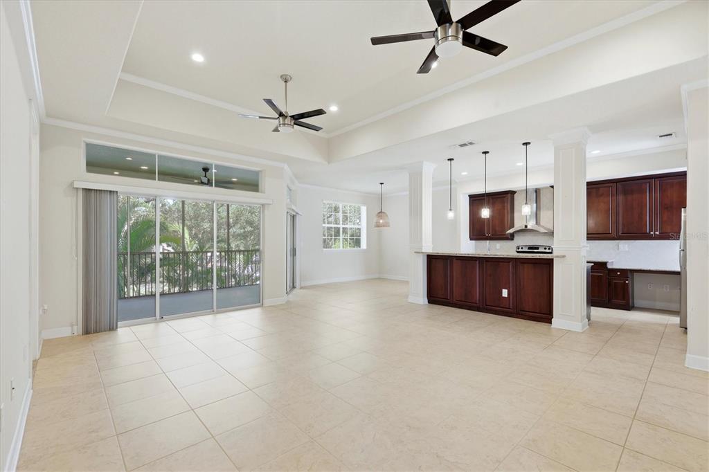 An open-concept living and kitchen area features tile flooring, dark wood cabinetry, and sliding doors — 7930 TYBEE COURT UNIT 7930, UNIVERSITY PARK, FL