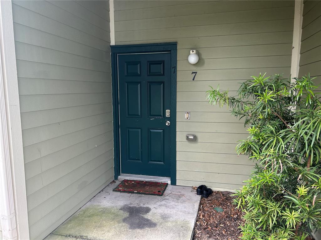 A dark green front door with the number seven is set into light green siding — 3717 S LAKE ORLANDO PARKWAY UNIT 7, ORLANDO, FL