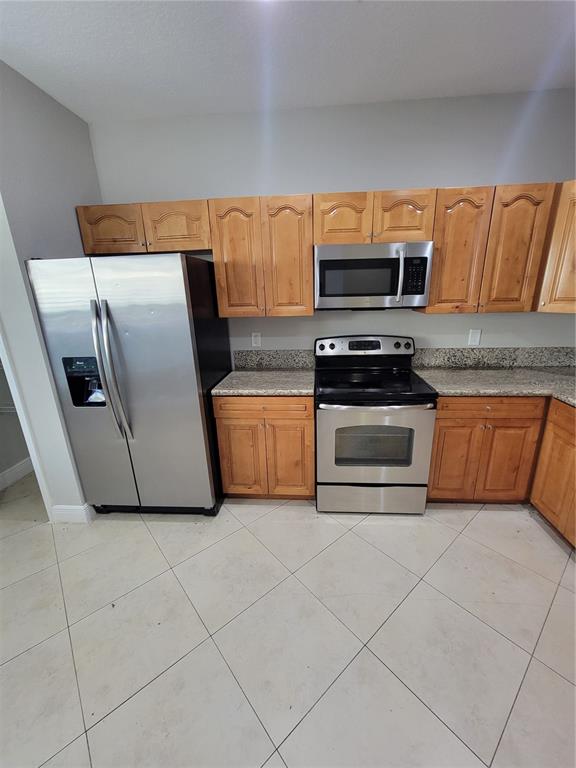 A kitchen features stainless steel appliances, light wood cabinets, and speckled granite countertops — 3717 S LAKE ORLANDO PARKWAY UNIT 7, ORLANDO, FL