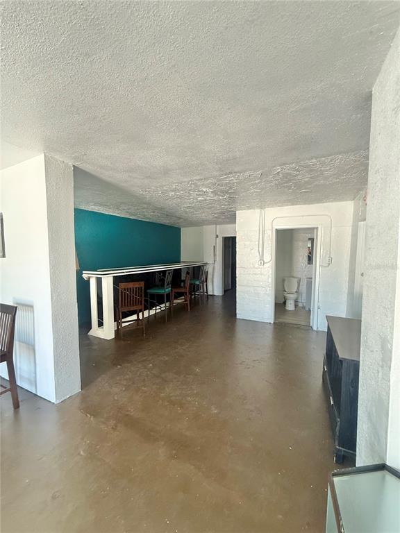 An open-concept room features a teal accent wall, a breakfast bar, and a bathroom — 840 16TH STREET S, ST PETERSBURG, FL