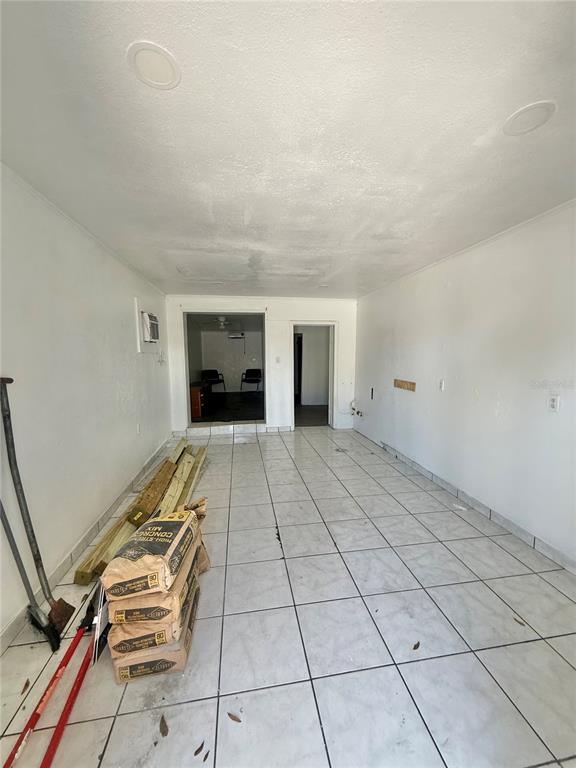 An empty room with white walls, tiled flooring, and a doorway leading to another space — 840 16TH STREET S, ST PETERSBURG, FL