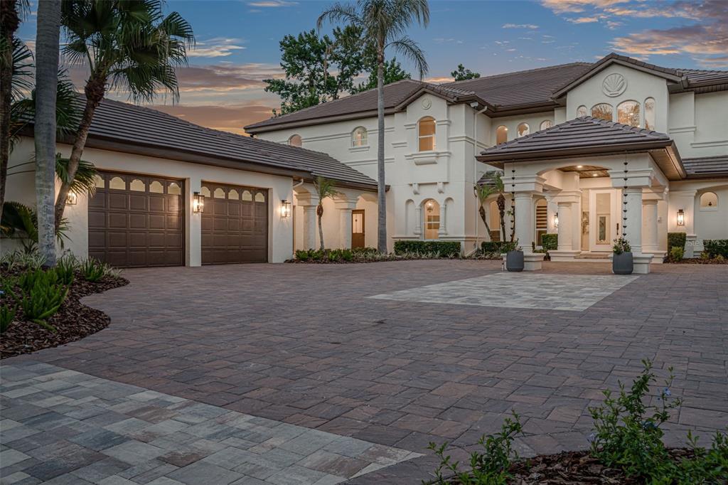 A large two-story house with a paved driveway, a three-car garage, and a covered entryway — 3147 TALA LOOP, LONGWOOD, FL