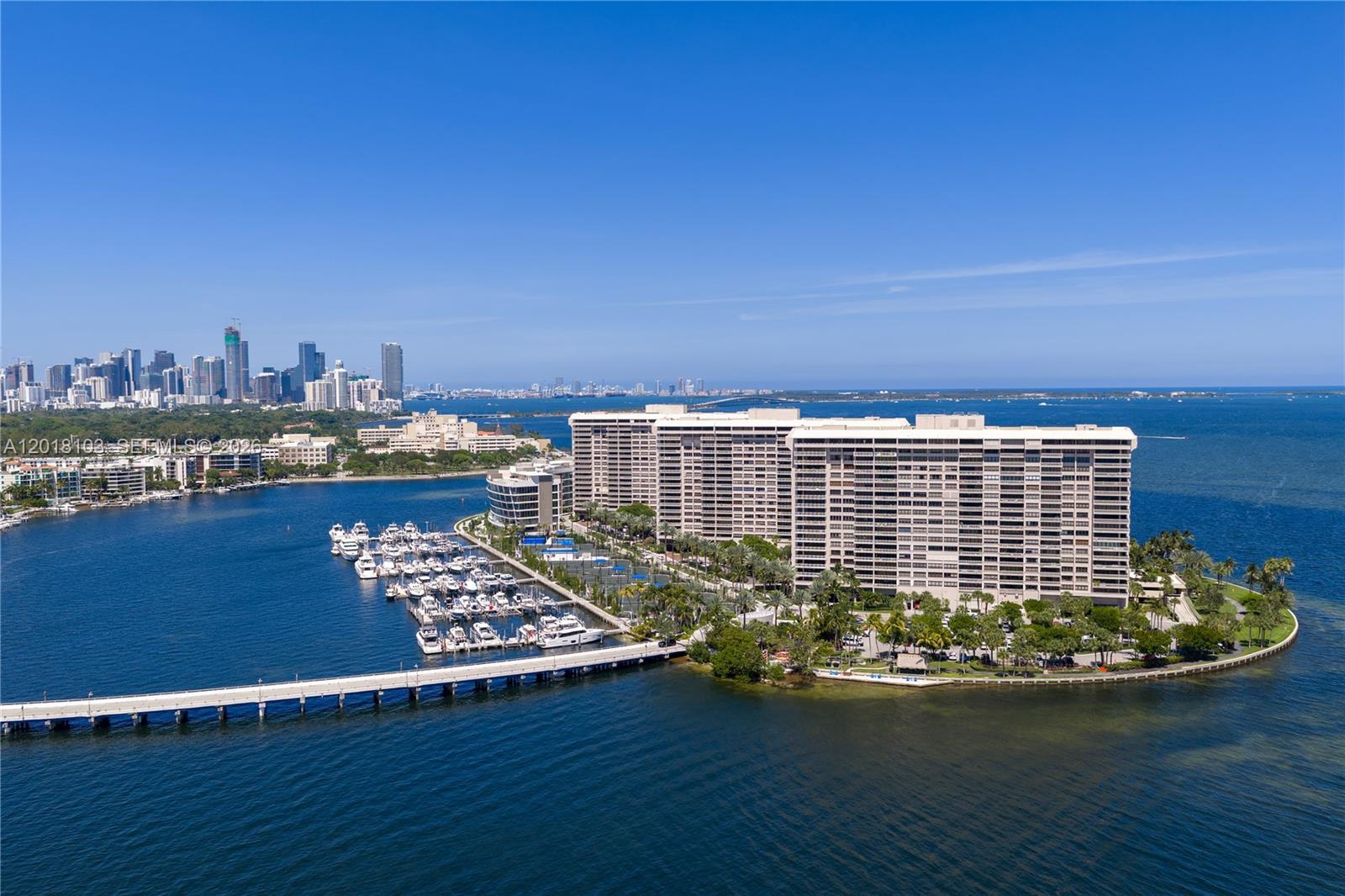 An aerial view shows a large residential complex on a peninsula with a private marina — 3 Grove Isle Dr # C410, Miami FL 33133, MIAMI, FL