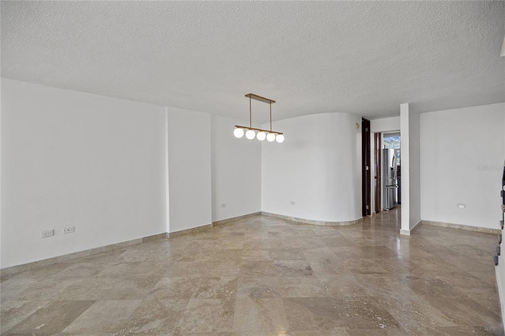 An empty room with white walls, a modern globe light fixture, and polished stone flooring — 146 Ave Santa Ana BOSQUE DE LA VILLA DE TORRIMAR UNIT C-PH-D, GUAYNABO, PR