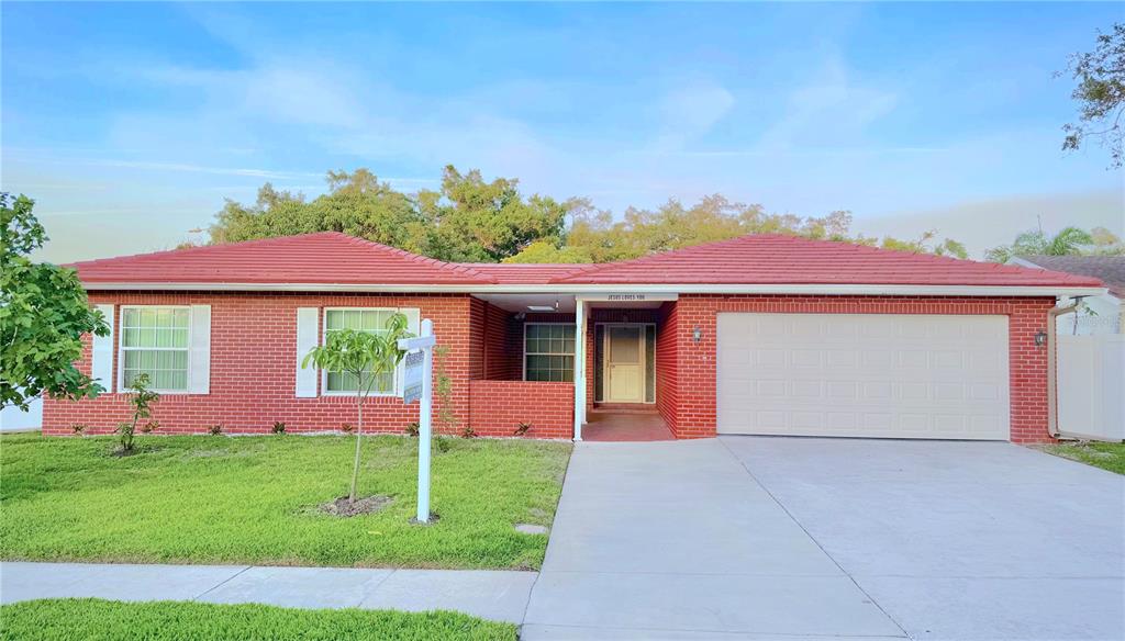 A single-story red brick house with a red tile roof and a two-car garage — 1929 VALENCIA WAY, CLEARWATER, FL