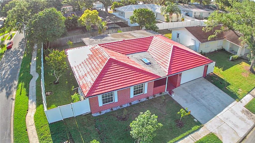 An aerial view of a single-story brick house with a red tile roof and driveway — 1929 VALENCIA WAY, CLEARWATER, FL