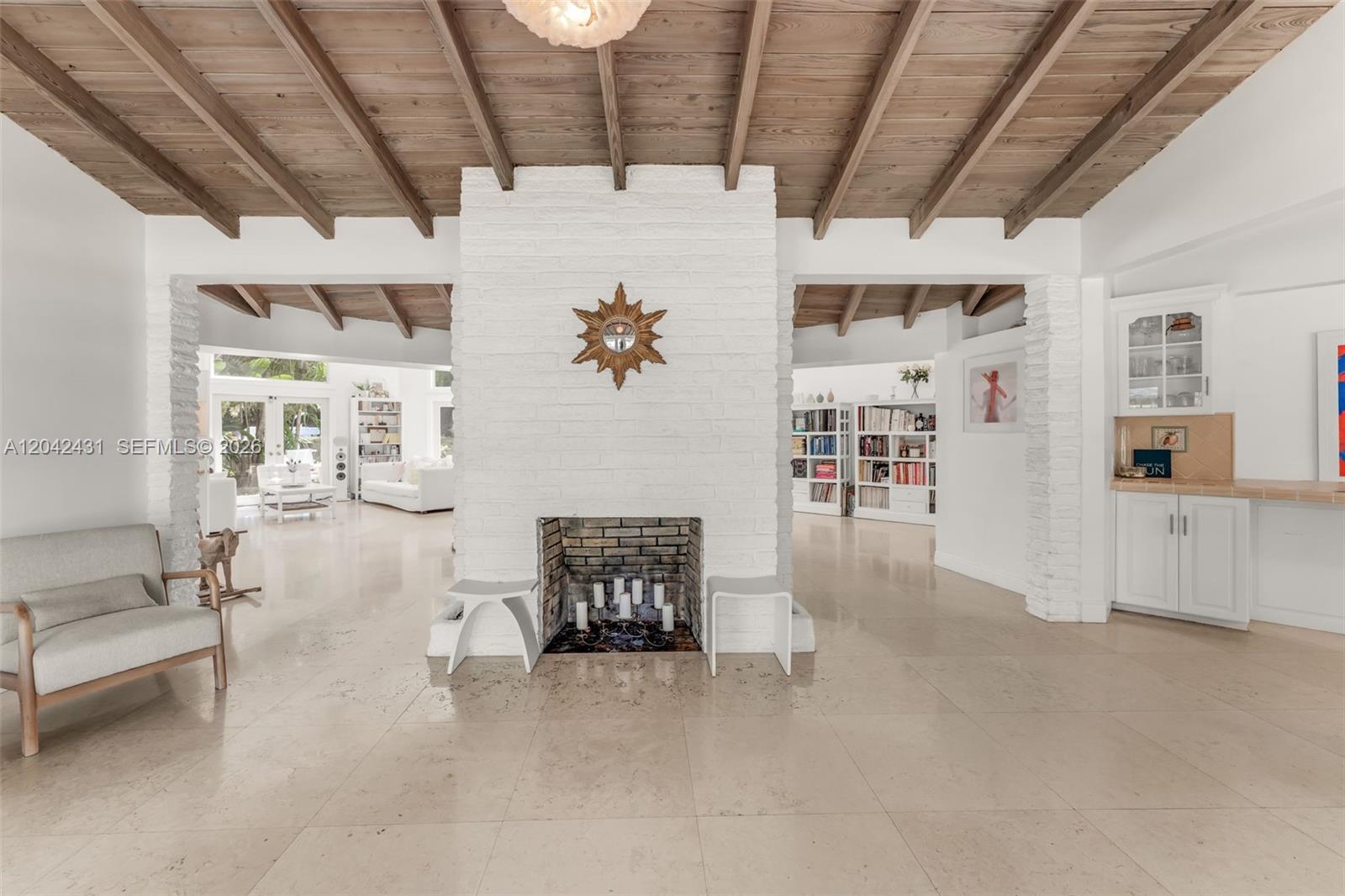 A white brick fireplace stands in a room with a vaulted wood-beamed ceiling — 7924 SW 50th Ct, Miami FL 33143, MIAMI, FL