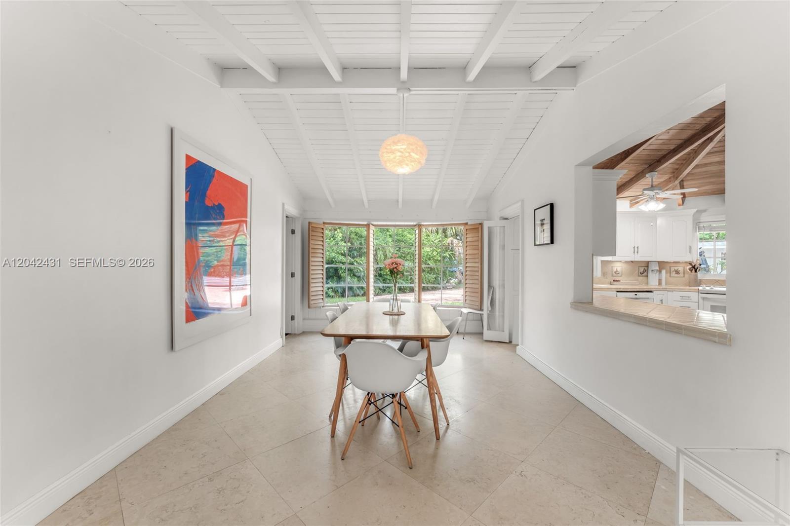 A dining room features a vaulted white ceiling, tile floors, and a large window view — 7924 SW 50th Ct, Miami FL 33143, MIAMI, FL