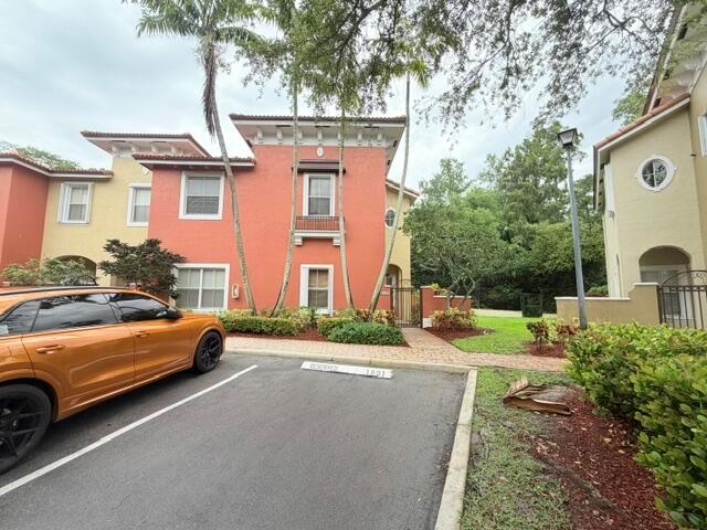 An orange multi-story building with a parking space in the foreground — 3126 Merrick Terrace # 1801, Margate FL 33063, MARGATE, FL