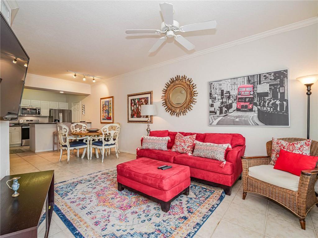 A living room features a red sofa, matching ottoman, patterned rug, and an adjacent dining area — 2288 57th Circle # 2288, Vero Beach FL 32966, VERO BEACH, FL