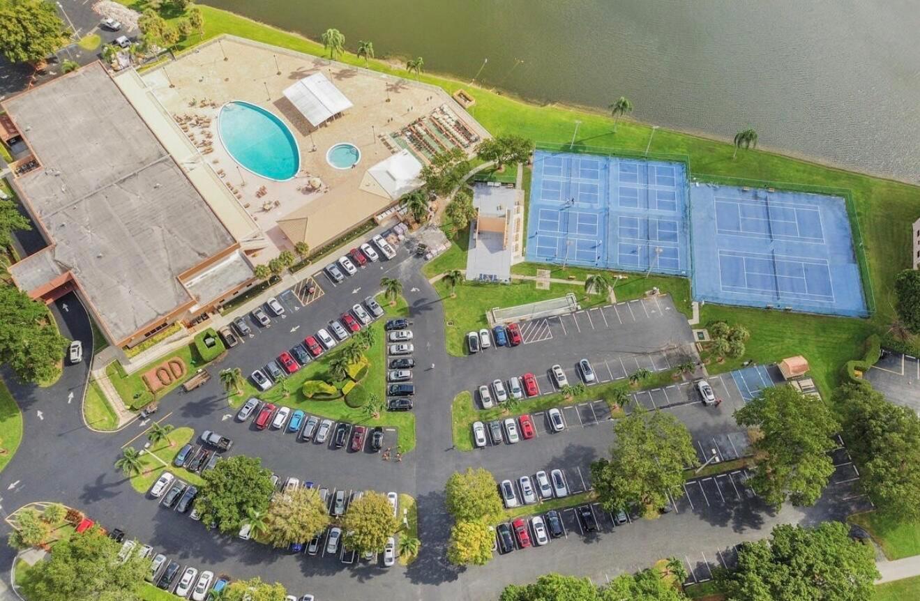 An aerial view shows a community center with a pool, tennis courts, and parking lots — 15072 Ashland Place S # 117, Delray Beach FL 33484, DELRAY BEACH, FL