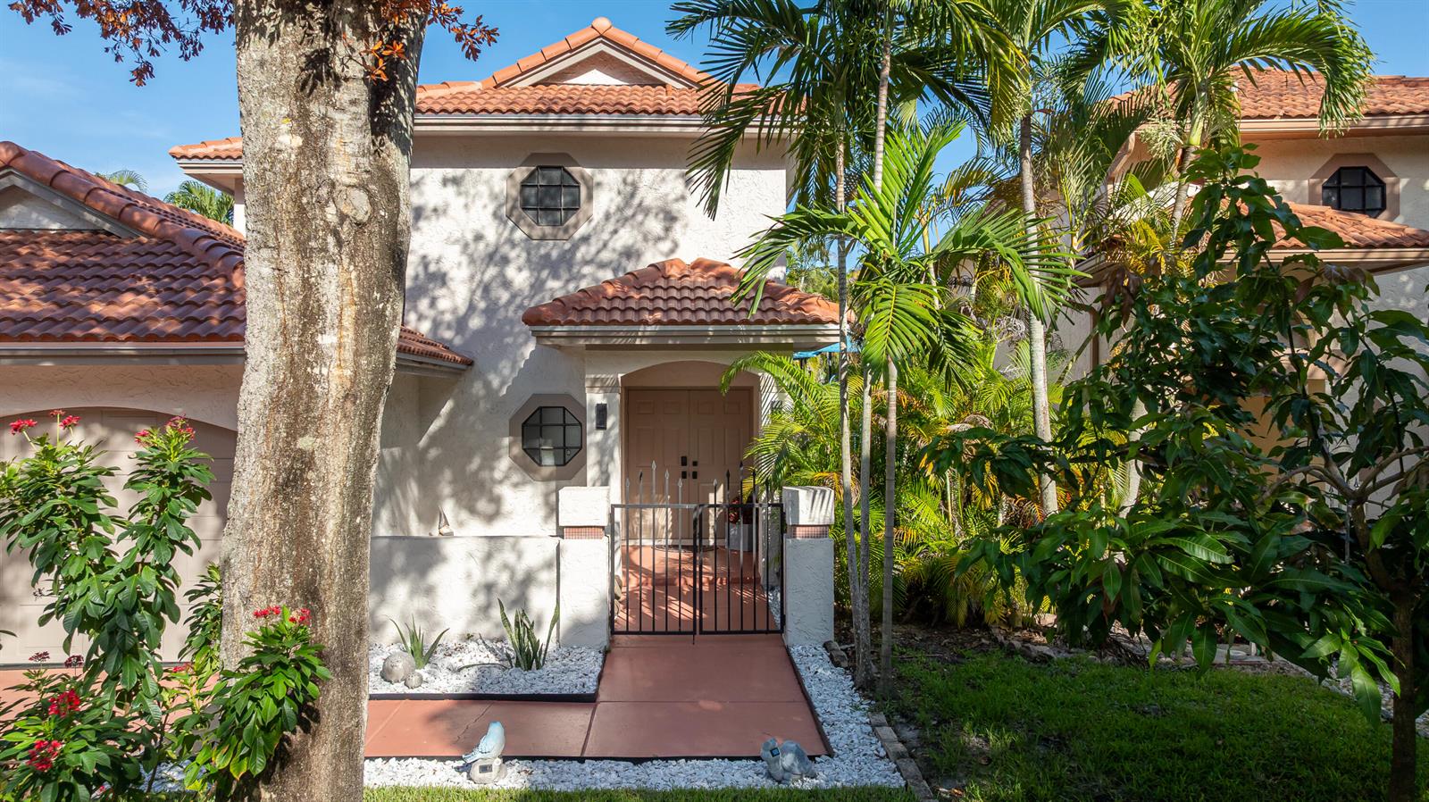 A two-story house with a tiled roof, gated entryway, and palm trees in the front yard — 484 NW 38th Terrace, Deerfield Beach FL 33442, DEERFIELD BEACH, FL