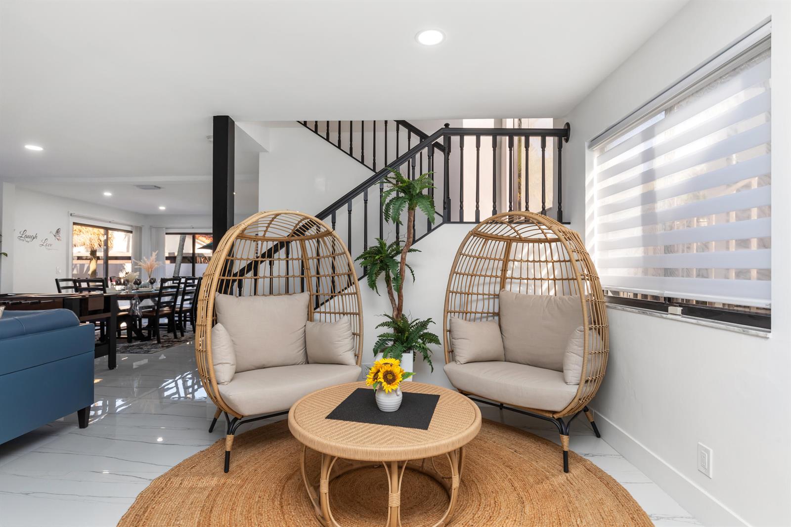 A seating area features two wicker egg chairs, a round table, and a staircase — 484 NW 38th Terrace, Deerfield Beach FL 33442, DEERFIELD BEACH, FL