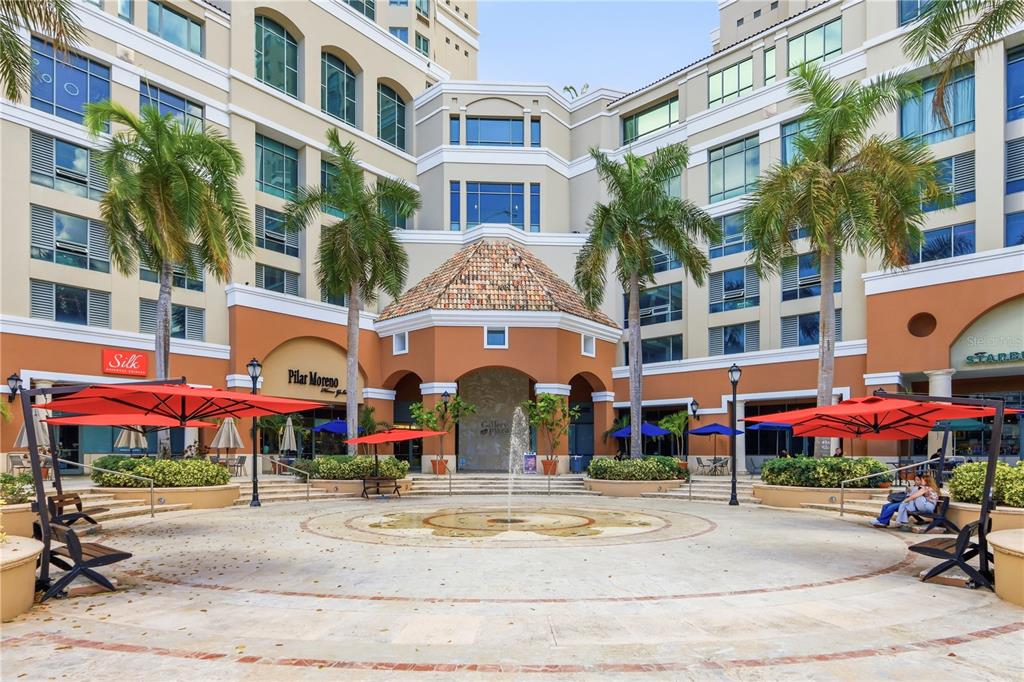 An outdoor plaza features a central fountain, palm trees, and surrounding commercial building storefronts — 103 DE DIEGO UNIT 903, SAN JUAN, PR