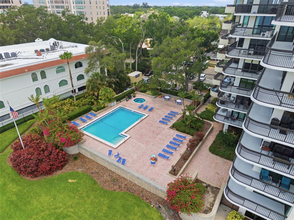An aerial view shows a swimming pool, hot tub, and patio area beside a high-rise building — 2413 BAYSHORE BOULEVARD UNIT 1004, TAMPA, FL