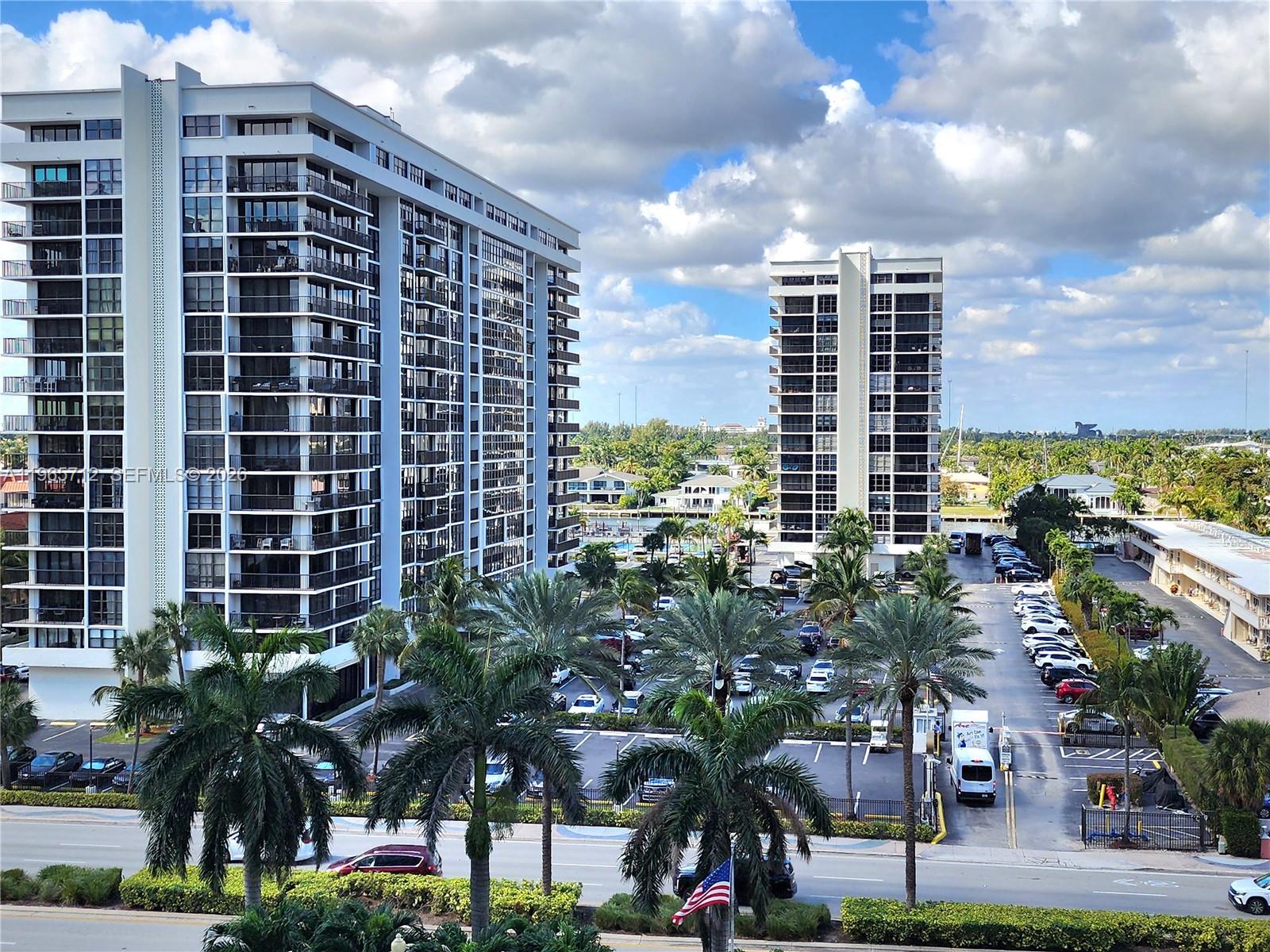 An elevated view shows two tall residential buildings overlooking a parking lot and palm trees — 2030 S Ocean Dr # 626, Hallandale Beach FL 33009, HALLANDALE BEACH, FL
