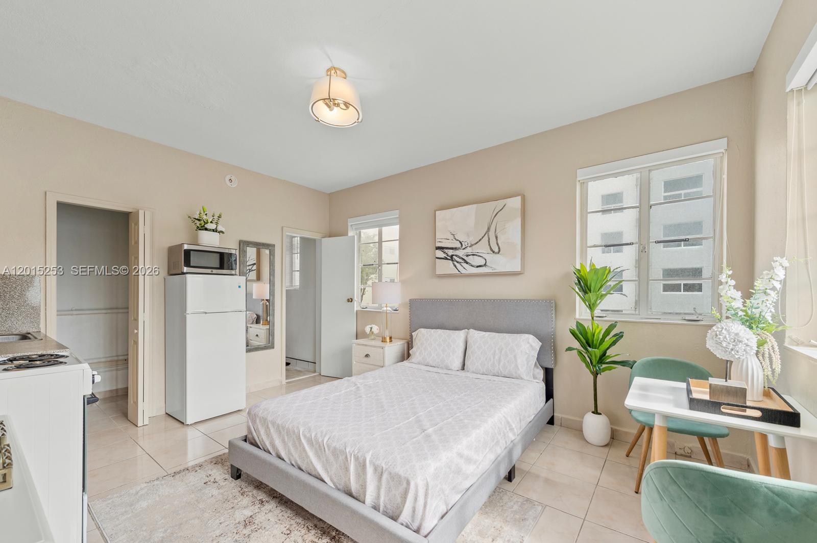 A studio apartment features a bed, a small dining area, and a kitchenette with a refrigerator — 301 86th St # 3A, Miami Beach FL 33141, MIAMI BEACH, FL