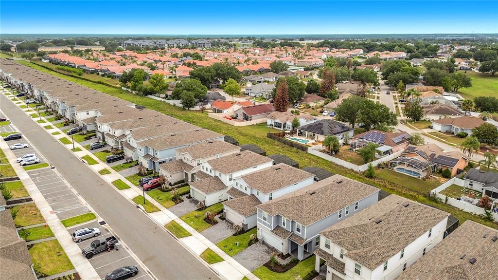 A two-story light blue house features a two-car garage, stone accents, and a paved driveway — 3859 LANA AVENUE, DAVENPORT, FL