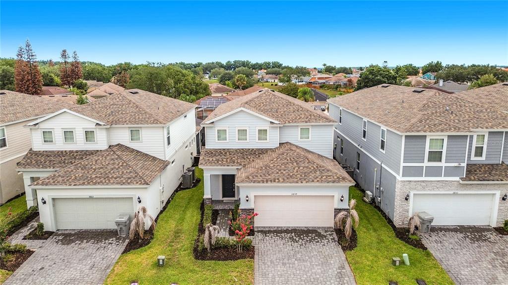 An open-concept living and dining area features tile flooring, a blue sofa, and a kitchen — 3859 LANA AVENUE, DAVENPORT, FL