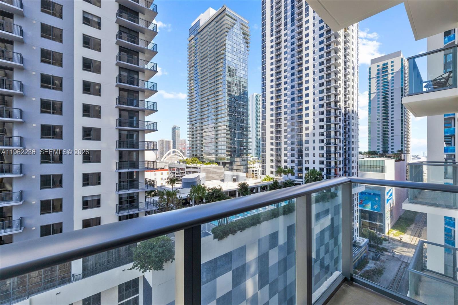 A view from a balcony overlooking several high-rise apartment buildings in a city — 11 NE 6th St # 1611, Miami FL 33132, MIAMI, FL