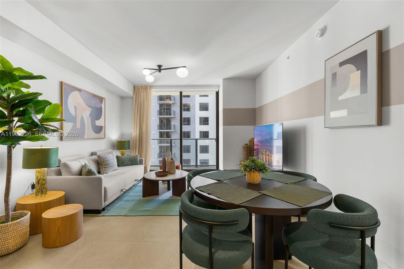 A living and dining area features a sofa, round table, and a balcony with city views — 11 NE 6th St # 1611, Miami FL 33132, MIAMI, FL