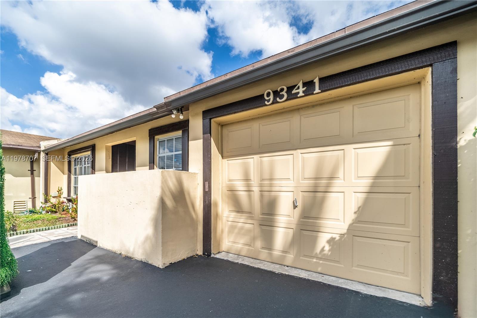 The exterior view shows a tan garage with the number 9341 above the door — 9341 E Fern Ln, Miramar FL 33025, MIRAMAR, FL