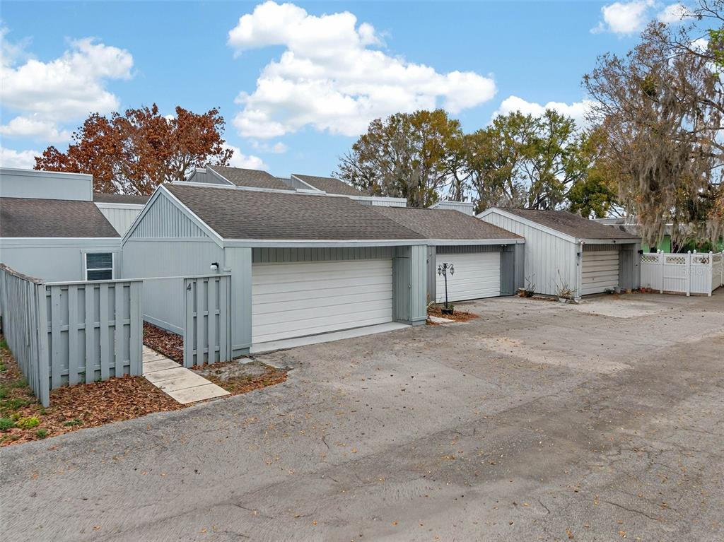 A row of light gray detached garages with asphalt roofs and a paved driveway — 1502 BUCKEYE ROAD NE UNIT 4, WINTER HAVEN, FL