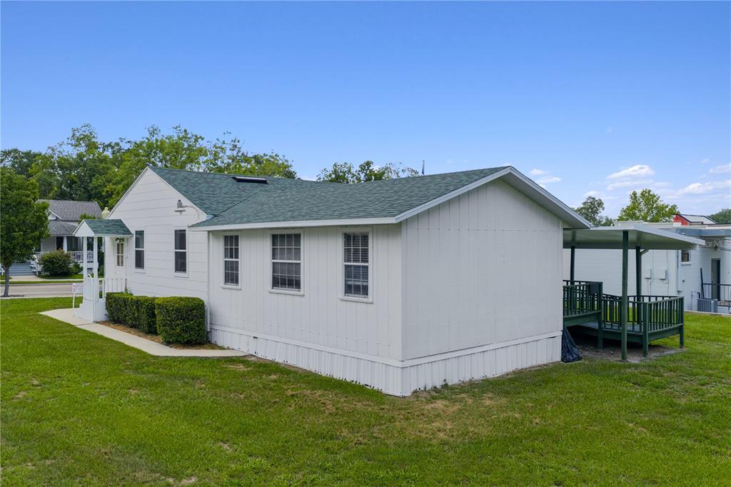 A white manufactured home with a green shingled roof and a side deck — 14721 MAIN STREET, ALACHUA, FL