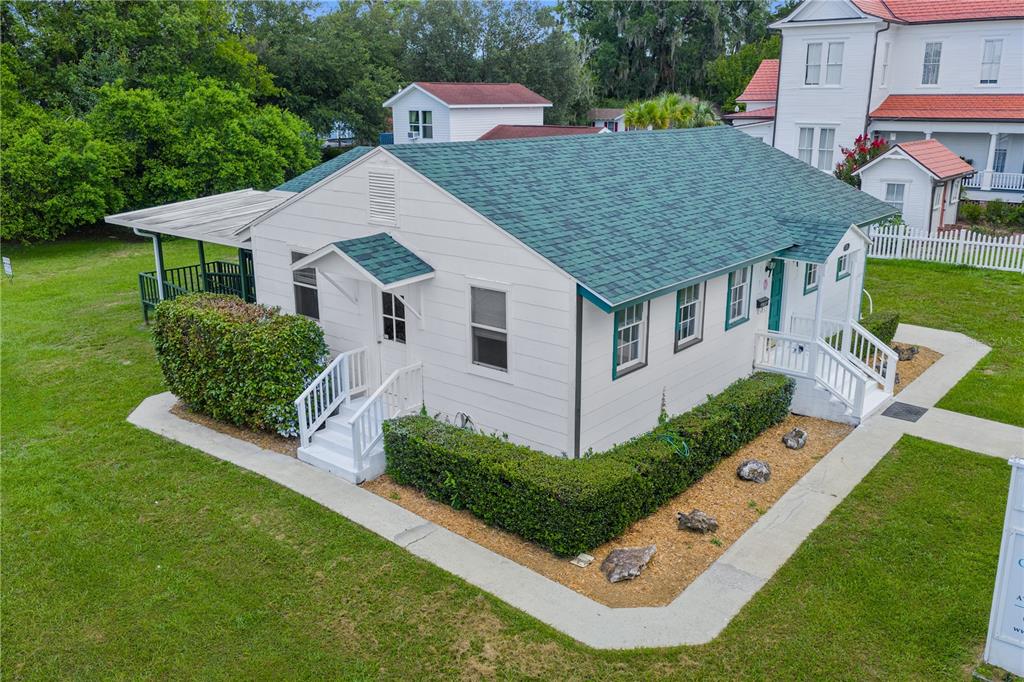 An aerial view of a white, single-story house with a green shingled roof — 14721 MAIN STREET, ALACHUA, FL