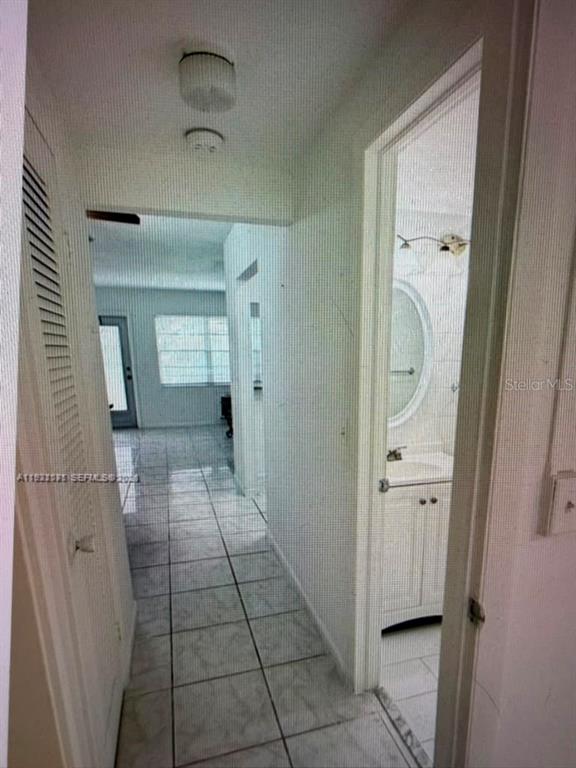 A hallway with tiled floors leads to a living area, with a bathroom on the right — 163 COVENTRY G UNIT 163, WEST PALM BEACH, FL