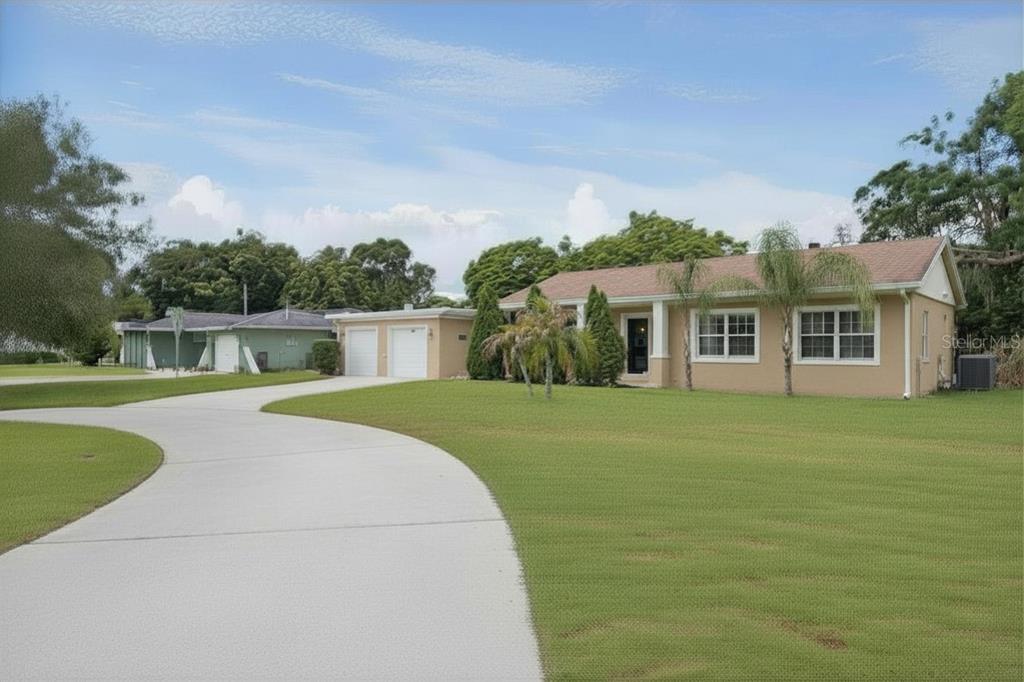 A pink house exterior features a white garage door, a front entrance, and a conifer — 78 S WINTER PARK DRIVE, CASSELBERRY, FL