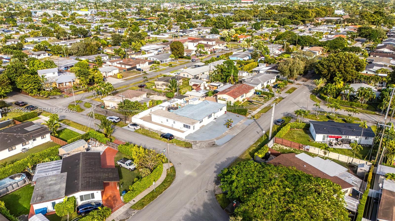 An aerial view shows a residential neighborhood with houses, streets, and surrounding trees — 9365 SW 44th St, Miami FL 33165, MIAMI, FL