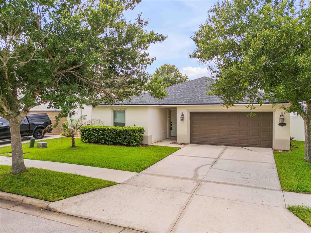 A single-story house with a beige exterior, a two-car garage, and a concrete driveway — 550 AEOLIAN DRIVE, NEW SMYRNA BEACH, FL