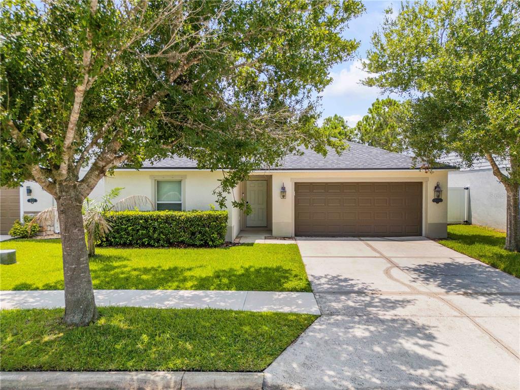 A single-story house with a brown garage door, light-colored stucco exterior, and a front lawn — 550 AEOLIAN DRIVE, NEW SMYRNA BEACH, FL