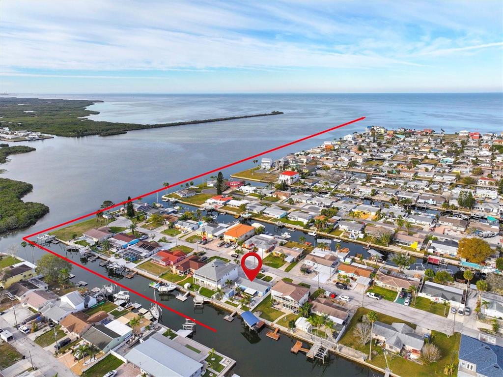 An aerial view shows a waterfront residential neighborhood with a red pin marking a house — 13604 MARIA DRIVE, HUDSON, FL