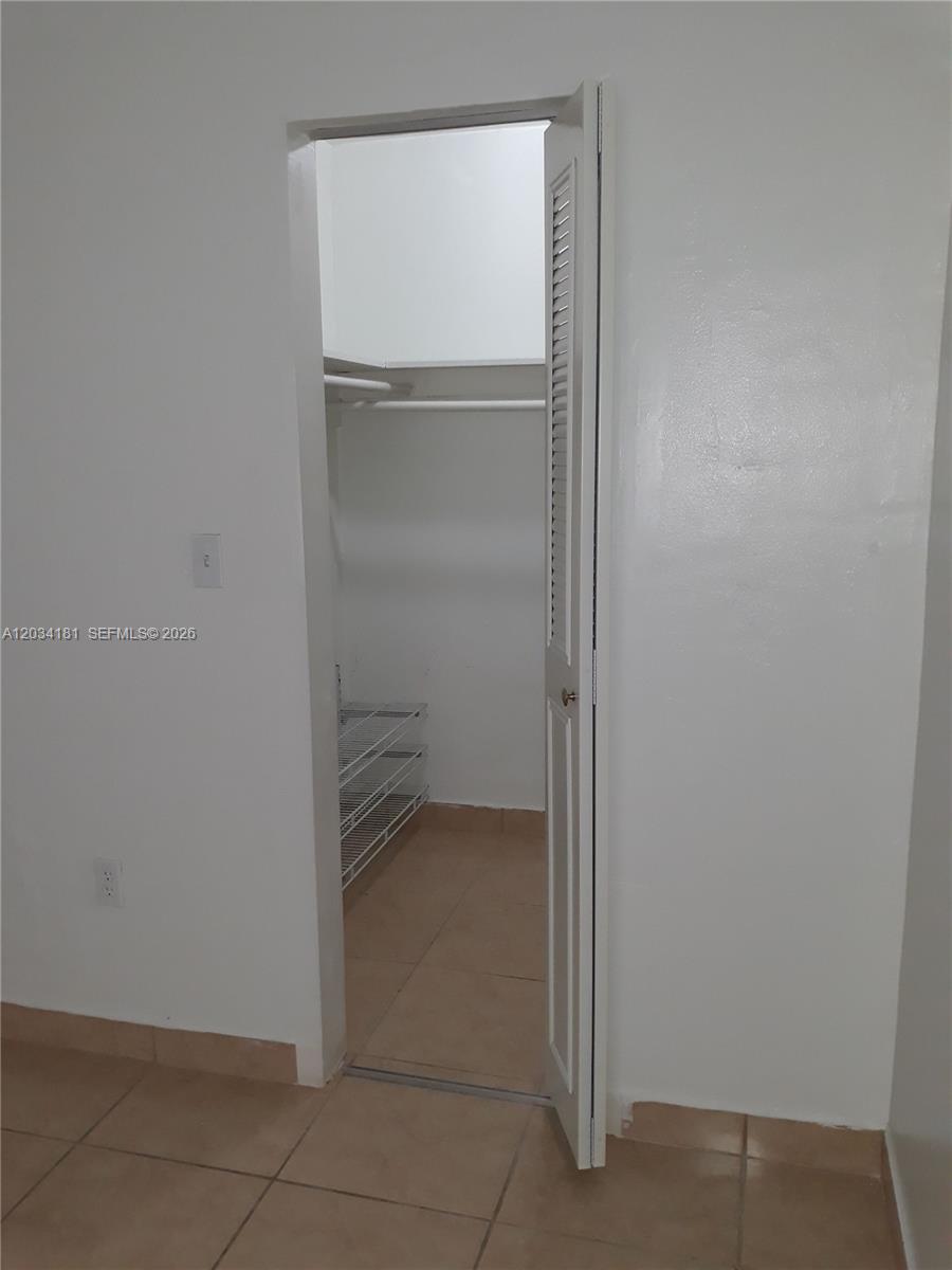 A white door opens into a small closet with wire shelving and tiled floors — 6850 W 14th Ct # A28, Hialeah FL 33014, HIALEAH, FL