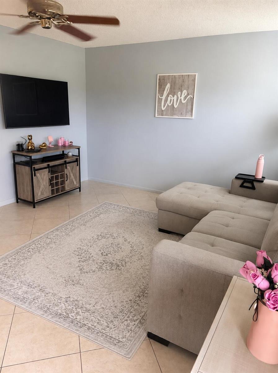 A living room features a sectional sofa, a television, a media console, and a rug — 2013 Lincoln A, Boca Raton FL 33434, BOCA RATON, FL